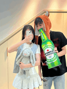 a girl taking a selfie with a heineken beer bottle