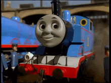 thomas the train is smiling and looking at the camera in a cartoon