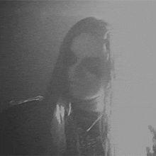 a black and white photo of a woman with long hair .