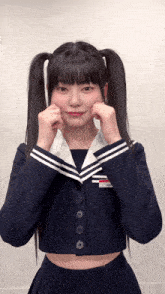 a girl in a sailor suit with pigtails making a funny face