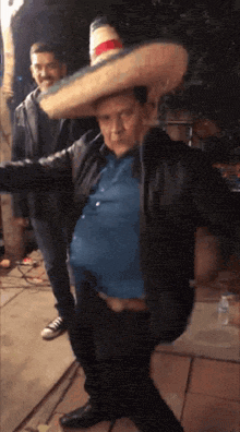 a man wearing a sombrero and a blue shirt is dancing