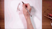 a person is drawing a picture of a woman 's face with colored pencils