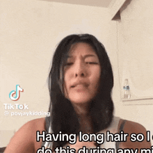 a woman with long hair is making a funny face and says `` having long hair so i do this during any mi '' .