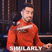 a man in a red shirt is sitting in front of a microphone and the word similarly is on the screen