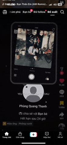 a phone screen shows a man sitting at a table with a cup in his hand
