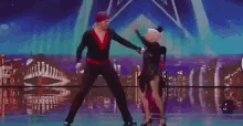 a man is carrying a woman in his arms on a stage .