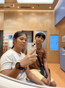 a boy and a girl are taking a picture of themselves in a store