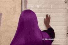 a woman with purple hair and a clown mask on her face is standing in a bathroom .