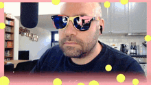a man with a beard wearing sunglasses with a reflection of a microphone