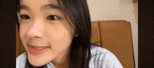 a close up of a young girl 's face while sitting on a chair .
