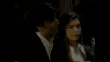 a man and a woman are standing next to each other under a tree .