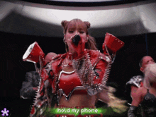 a woman singing into a microphone with the words hold my phone written below her