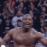 a man without a shirt stands in front of a crowd with a star in the background