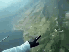 a person is giving a thumbs up while standing in the water .