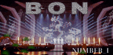 the word bon is on a stage with a tree on it
