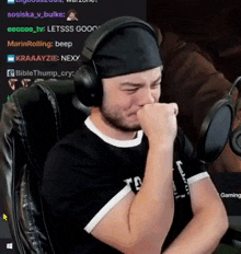a man wearing headphones is sitting in front of a microphone and crying .