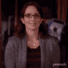 a close up of a woman wearing glasses and a peacock logo in the corner