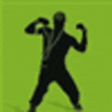 a silhouette of a man is flexing his muscles in front of a green background .