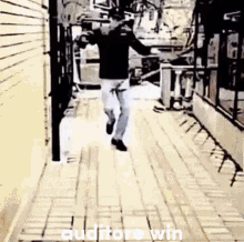 a man is running down a sidewalk with the words `` auditore win '' written on the ground .