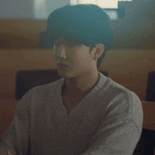 a man wearing a sweater and earrings looks down