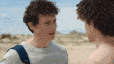 two young men with curly hair are talking to each other