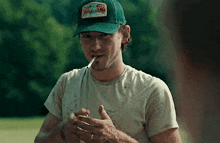 a man wearing a hat is smoking a cigarette .