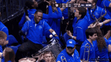 a group of people in blue shirts with the word ncaa on the screen
