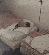a young man is sleeping on a bed with a white pillow