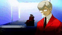 a man in a red suit and tie is standing in front of a woman in a wheelchair