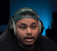 a man wearing headphones and a green hat that says jets