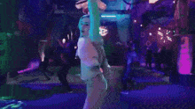 a person is doing a karate kick in a dark room with a lot of lights .