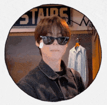a man wearing sunglasses in front of a sign that says stairs on it