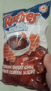 a person is holding a bag of ruffles chips