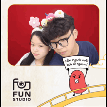 a boy and a girl are posing for a picture in front of a sign that says fun studio