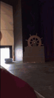 a steering wheel sits on a stage in front of a red curtain