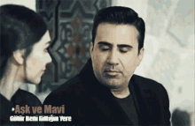 a man and a woman are looking at each other with the words ask ve mavi in the corner .