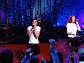 a group of women singing on a stage with a nbc logo in the corner