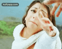 a woman is covering her face with her hand while a man holds her hand .