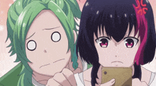 a girl with purple hair is looking at a cell phone next to a girl with green hair
