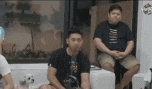 a group of men are sitting in a room with a small dog .