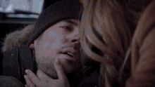 a woman is touching a man 's face with her hands