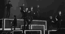 a black and white photo of a group of people dancing on a stage .