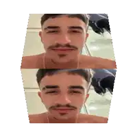 a shirtless man with a mustache is looking at the camera .