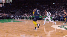 a basketball game is being played on a court with a player wearing a number 12 jersey .