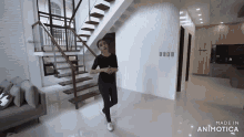 a woman is standing in front of a wooden staircase in a living room .
