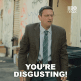 a man in a suit and tie is saying " you 're disgusting "
