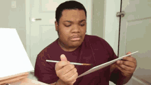 a man holding a brush and a piece of paper
