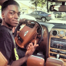 a man is sitting in a bentley car and giving the middle finger