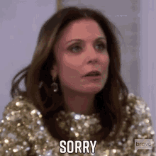 a woman is wearing a gold sequined dress and says sorry .