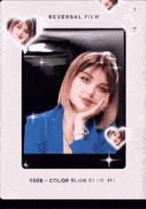 a woman in a blue jacket is taking a picture with her hand on her chin .